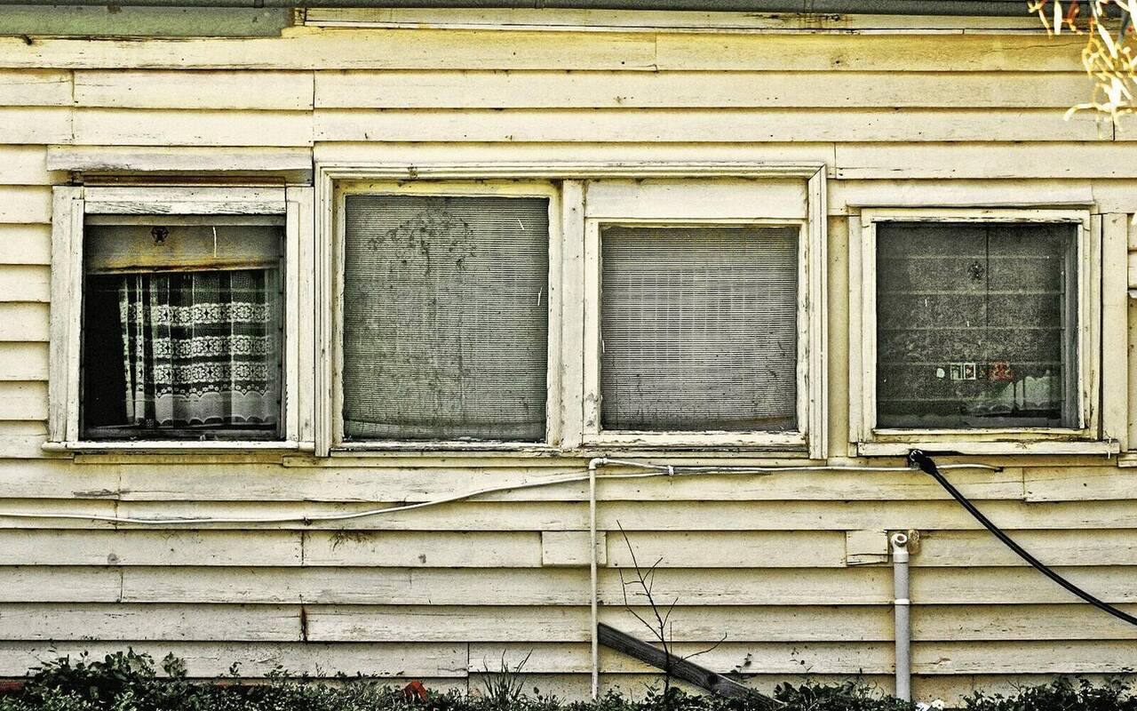 The original tired weatherboard house before the rebuild.